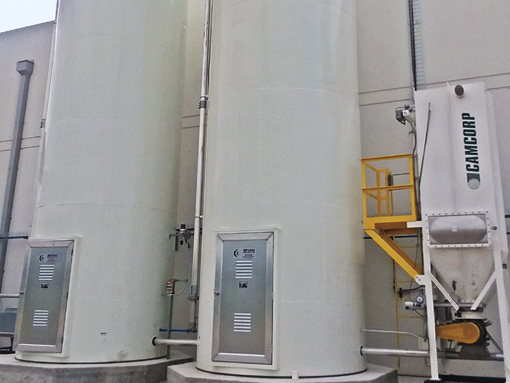 Two adjacent, sizeable white silos positioned in close proximity to each other